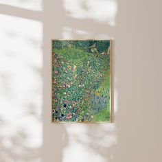 a painting hanging on the wall in front of a window with sunlight streaming through it