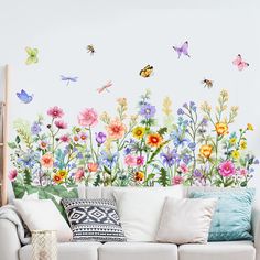 a living room with flowers and butterflies painted on the wall