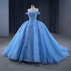 Step into a world of opulence and grace with this Elegant Blue Sequins Ball Gown. This dress is crafted from luxurious blue tulle and features a voluminous ball gown silhouette, flowing effortlessly into a dramatic cathedral train that adds an air of regal sophistication. The off-the-shoulder neckline enhances the dress’s romantic appeal, beautifully framing your shoulders while offering a flattering, feminine touch. The exquisite appliqued details and sparkling sequins on the bodice catch the l Sequin Ball Gown, Evening Party Dresses, Blue Ball Gowns, White Homecoming Dresses, Party Dress Sale, Stunning Prom Dresses, Blue Homecoming Dresses, Blue Party Dress, Quinceanera Dress