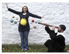 a woman juggling balls with a man in front of her and an object on the ground behind her