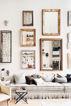 a living room filled with furniture and framed pictures on the wall above it's couch