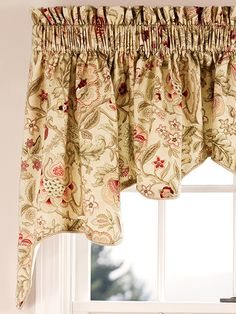 a window with a floral curtain hanging from it's valance in front of a window