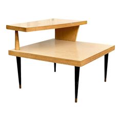 a wooden table with black legs and an open shelf on one side, against a white background