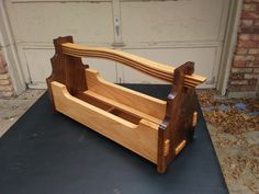 a wooden bench sitting on top of a black mat in front of a garage door