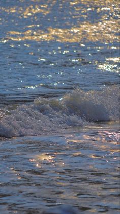 a person riding a wave on top of a surfboard in the ocean at sunset