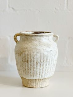 a white vase sitting on top of a table