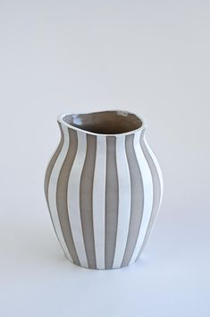 a gray and white striped vase sitting on top of a table