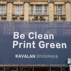 a large blue sign that says be clean print green on the side of a building