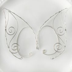 Intricate wire elf ears. Adjustable fitting that wraps around your ear. Very lightweight and secure fit. Comes in a pair.  DETAILS - comes in a pair - overall length is 3.5 inches - adjustable fit - lightweight and easy to wear - nickel and lead free - securely packaged in a signature gift box Adjustable Fantasy Wrap Earrings As Gift, Adjustable Fantasy Wrap Earrings For Gift, Handmade Fantasy Wrap Earrings, Adjustable Wire Wrapped Fantasy Earrings, Whimsical Adjustable Ear Cuff For Festivals, Adjustable Wrap Earrings With Ear Wire For Festivals, Adjustable Wrap Earrings For Festival, Whimsical Adjustable Silver Ear Cuff, Adjustable Silver Whimsical Ear Cuff