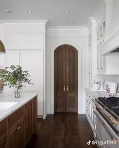 a kitchen with white cabinets and wood floors is pictured in this image from the front door