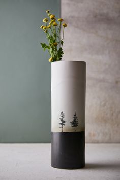 a vase with flowers in it sitting on a table next to a wall and window