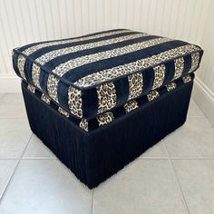 a leopard print ottoman cover on top of a white tile floor