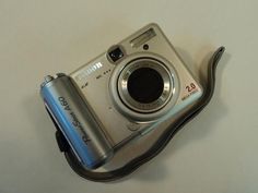 a silver camera sitting on top of a white table