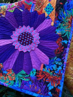 a purple and blue quilt with flowers on it