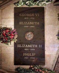 the memorial plaque is surrounded by flowers and greenery