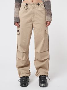 Arm yourself with ’90s and noughties attitude! Take a look at our cargo parachute pants in beige, featuring a baggy fit, utility pockets and adjustable toggle waist and hems. Find y2k pants, retro trousers & more aesthetic clothes at Minga London. Tech Cargo Pants, Jeans With Chains, 90s Pants, Retro Trousers, Minga London, Denim Button Skirt, Low Rise Flare Jeans, Y2k Pants, Y2k Jeans