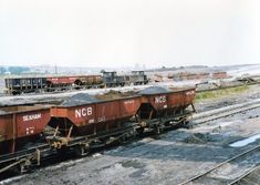 an old train car is sitting on the tracks near other rail cars and freight containers