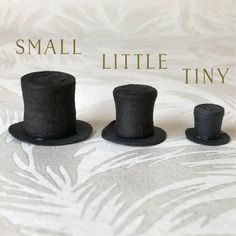 three small black top hats sitting next to each other on a white surface with the words small little tiny above them