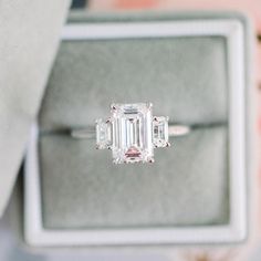 an engagement ring with three emerald cut diamonds