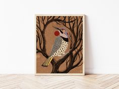 a bird sitting on top of a tree branch next to a wall mounted art piece