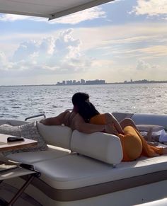 a woman is lounging on the back of a boat