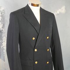 This 1960s German vintage double-breasted naval officer's jacket has peak lapels and padded shoulders, and closes in the front with two gold anchor buttons (six in total show on the front). The handsome blazer has three pockets on the front, and the left chest pocket has small pinholes where a patch was removed. The jacket is lined in a navy blue satin viscose fabric, and has three inner pockets. Brand label: Kleiverfabrik Knab (Germany) Size: 36 US/UK Material: 55% polyester, 45% wool Condition Gold Double-breasted Blazer, Gold Tailored Double-breasted Outerwear, Navy Pea Coat With Buttons For Formal Occasions, Navy Formal Pea Coat With Buttons, Military Double-breasted Pea Coat With Double Button Closure, Military Style Double-breasted Pea Coat, Navy Double-breasted Blazer With Buttons, Classic Gold Double-breasted Outerwear, Classic Gold Outerwear With Double-breasted Buttons