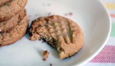 two cookies sitting on top of a white plate next to an orange striped table cloth