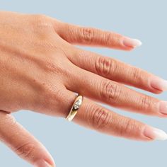 a woman's hand with a ring on her left wrist and two rings on the other