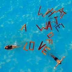 two people floating in the blue water with words written on them