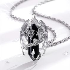 a black and white photo of a necklace with an image of a dragon on it