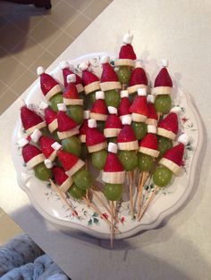 a platter filled with fruit wrapped in santa's hats on toothpicks