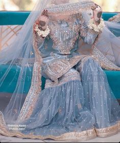 a woman in a blue bridal gown sitting on a couch