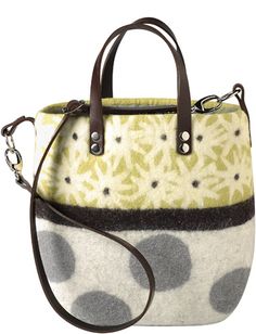 a handbag that is sitting on top of a white surface with black and yellow spots