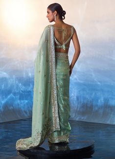 Elevate your elegance with the stunning Sea Green Sequinned Tissue Saree, meticulously crafted from premium tissue fabric. This exquisite sea green saree features a beautifully embellished border adorned with delicate crystal beadwork and sequins, adding a touch of sparkle to its ethereal charm. The lightweight tissue fabric drapes gracefully, creating a flattering silhouette. Paired with a matching blouse, intricately embroidered to complement the saree. A perfect ensemble for Mehendi, Sangeet, Cocktail and Reception and wedding guests. Composition : Saree and Blouse - Tissue Care: Dry Clean Only and Vacuum Storage This product can be customized for sleeves, length and colour Delivery : 6-8 weeks as the product is hand crafted. Check Size Guide or choose MySize for free customisation (All Green Embellished Pre-draped Saree For Wedding, Embellished Raw Silk Saree, Elegant Pista Green Dola Silk Pre-draped Saree, Traditional Embellished Tissue Silk Pre-draped Saree, Embellished Tissue Silk Saree For Festivals, Festive Embellished Tissue Silk Saree, Embellished Tissue Silk Saree, Embellished Green Georgette Saree, Embellished Tissue Silk Saree For Eid