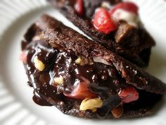 two chocolate desserts on a white plate with strawberries