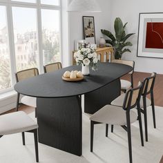 a dining room table with four chairs and a bowl of fruit on the table in front of large windows