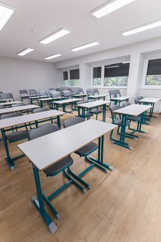 an empty classroom with desks and chairs in the middle, windows on both sides