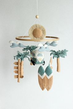 a baby mobile with an animal and palm trees hanging from it