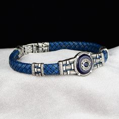 Silver Leather Evil Eye Bracelet , Silver Handmade Bracelet , Blue Sapphire Stone Bracelet , Greek Style Bracelet , 925k Silver Bracelet ★Item Details * Material : 925K Sterling Silver * Total weight :  19 Grams ✔ Ready to Ship in 1-2 Business Days .. ✔ Shipped to the Worldwide 1-5 business days with free shipping... ✔ The product will be sent to you with a handmade wooden box to avoid any damage during shipping... ✔ Visit our store, browse other Men's jewelry, silver and gold collections, and f Luxury Sapphire Round Bracelets, Luxury Blue Jubilee Bracelet, Luxury Blue Sterling Silver Bracelet, Adjustable Blue Bracelet For Formal Occasions, Sapphire Jubilee Bracelet, Elegant Adjustable Blue Leather Bracelet, Elegant Blue Adjustable Leather Bracelet, Luxury Blue Bracelet Strap Jewelry, Elegant Sterling Silver Leather Bracelet