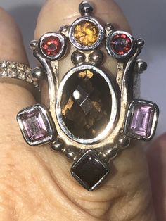 Amazing unique big gemstone ring smoky quartz, amethyst, Garnet and citrine. Ring sterling silver 925 Queen/ Royal Statement Size 10. Amazing ring. Extremely unique, I've never seen one like it. It truly feels like a medieval piece of jewelry that a queen or king would wear. Unusual and abstract piece. Would be perfect for a statement piece or even a Renaissance fair. The ring is well-made and solid. Signed 925. Elegant Sterling Silver Amethyst Ring, Elegant Silver Amethyst Ring With Large Stone, Unique Amethyst Ring With Accent Stones, Unique Amethyst Multi-stone Rings, Unique Multi-stone Amethyst Ring, Multi-stone Amethyst Ring, Unique Multi-stone Amethyst Ring For Anniversary, Unique Multi-stone Amethyst Ring For Gift, Smoky Quartz Gemstone Ring Jewelry