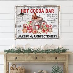 a sign on the wall above a table with christmas decorations and candles in front of it