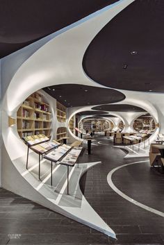 the interior of a library with bookshelves and tables on either side of it