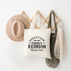 a white tote bag hanging on a wall next to a hat and other items