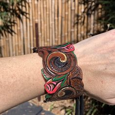 a close up of a person's arm wearing a bracelet with an owl on it