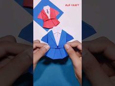 someone is folding an origami shirt and tie into a card with their hands