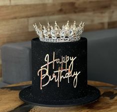 a black and gold birthday cake with a crown on top