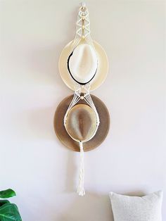 a wall mounted hat rack with hats hanging from it's sides and a pillow on the floor next to it