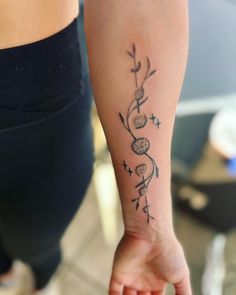 a woman with a tattoo on her arm holding the hand of another person's wrist