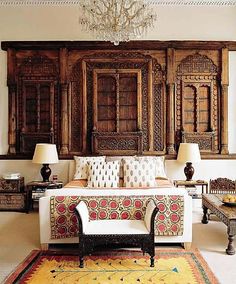 a living room filled with lots of furniture next to a wall covered in wooden paneling