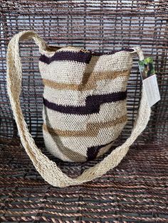 a brown and white bag sitting on top of a wicker chair next to a plant